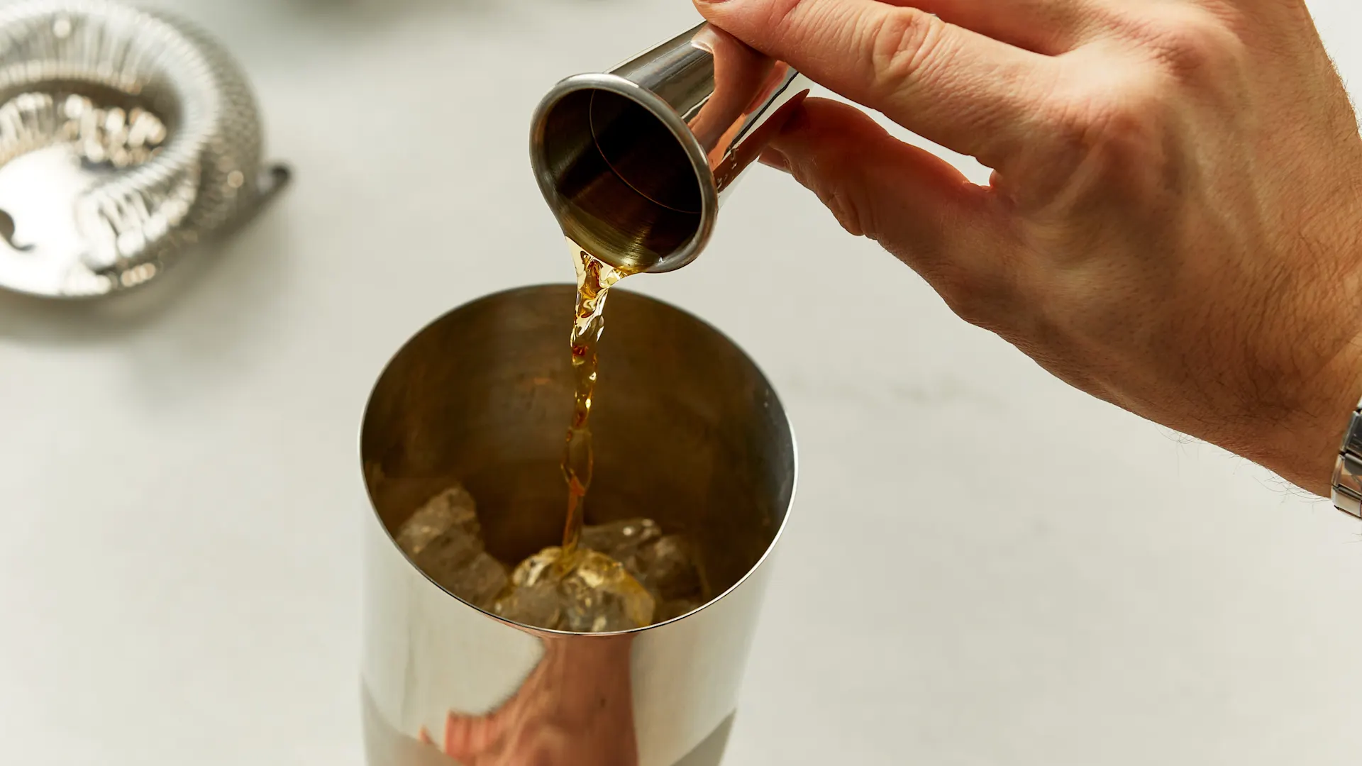 Whisky wordt in een cocktailshaker gegoten