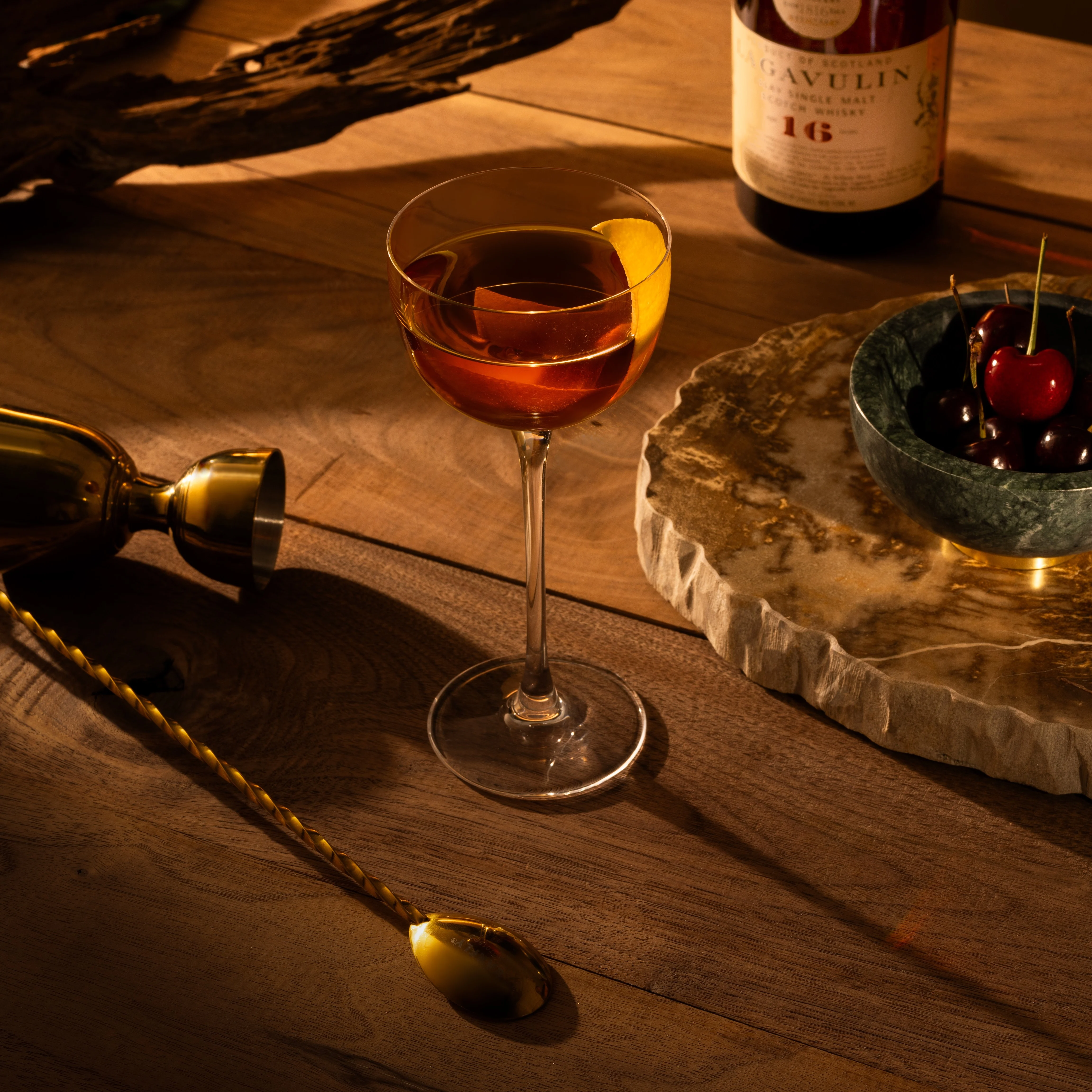 Ein Cocktail in einem Coupe-Glas mit einem Zitronenschalen-Twist