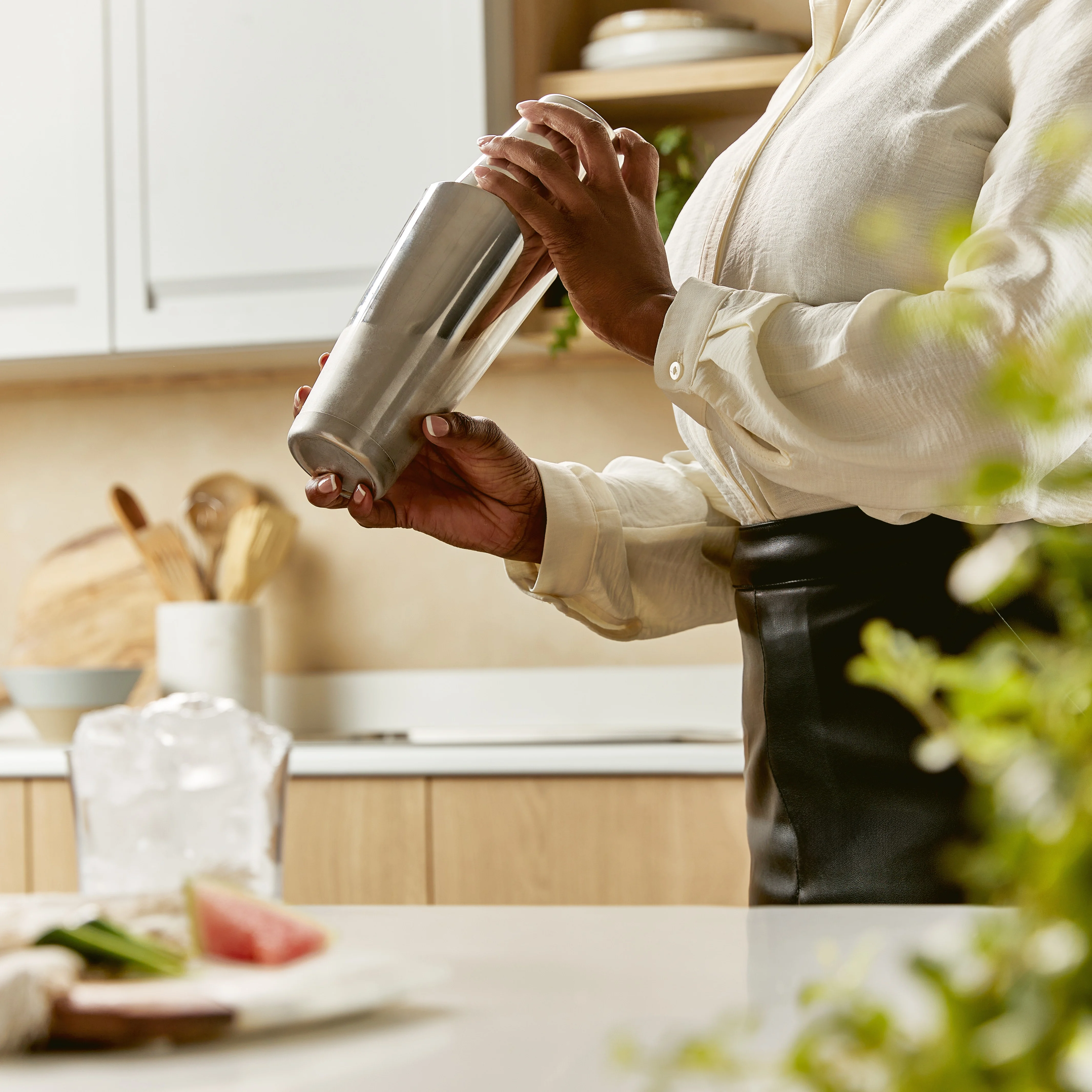 Frau schüttelt einen Cocktailshaker