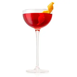 Een Paper Plane cocktail in een coupeglas met een garnering van citroenschil.