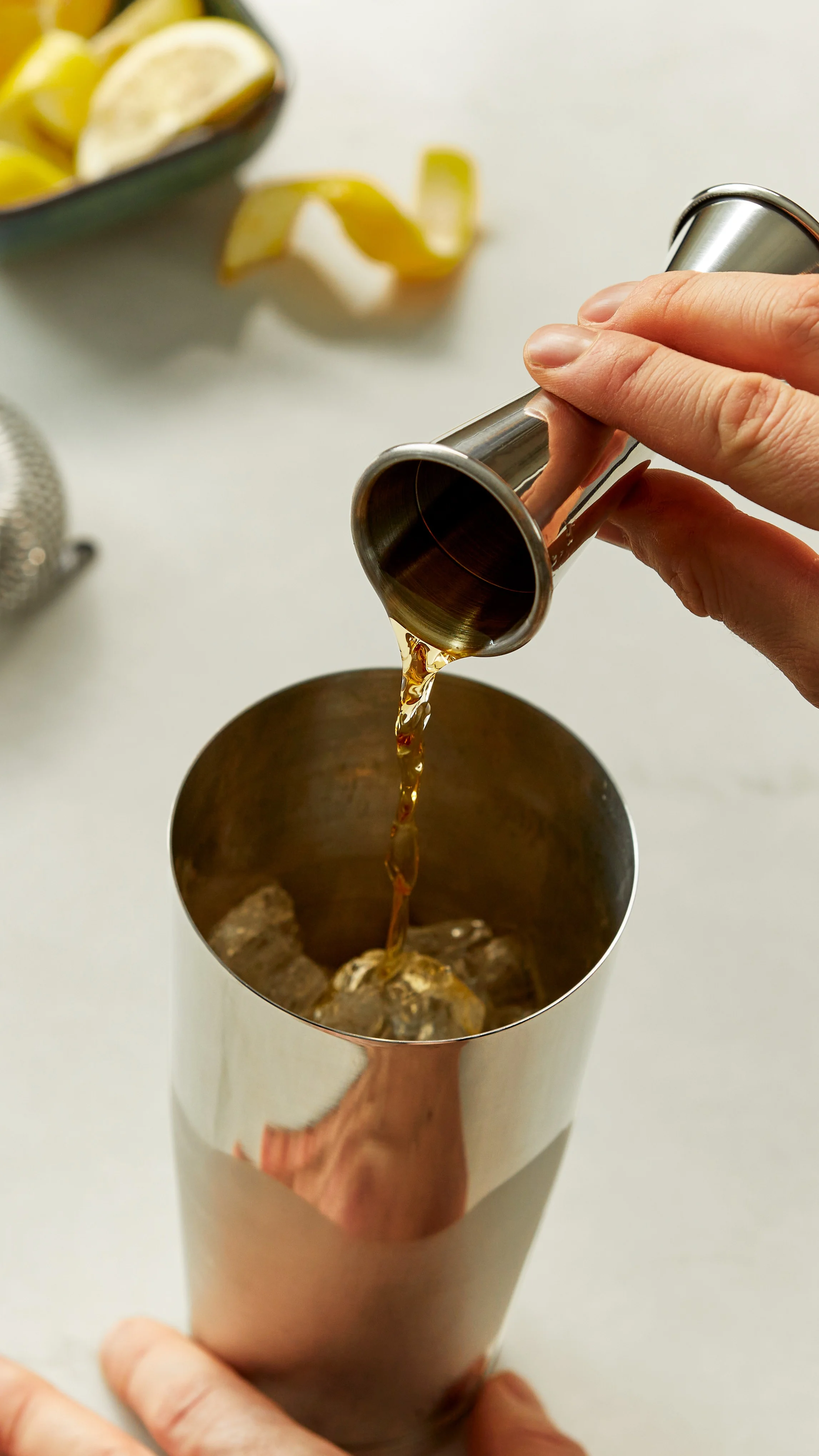 Whisky wird in einen Cocktailshaker gegossen