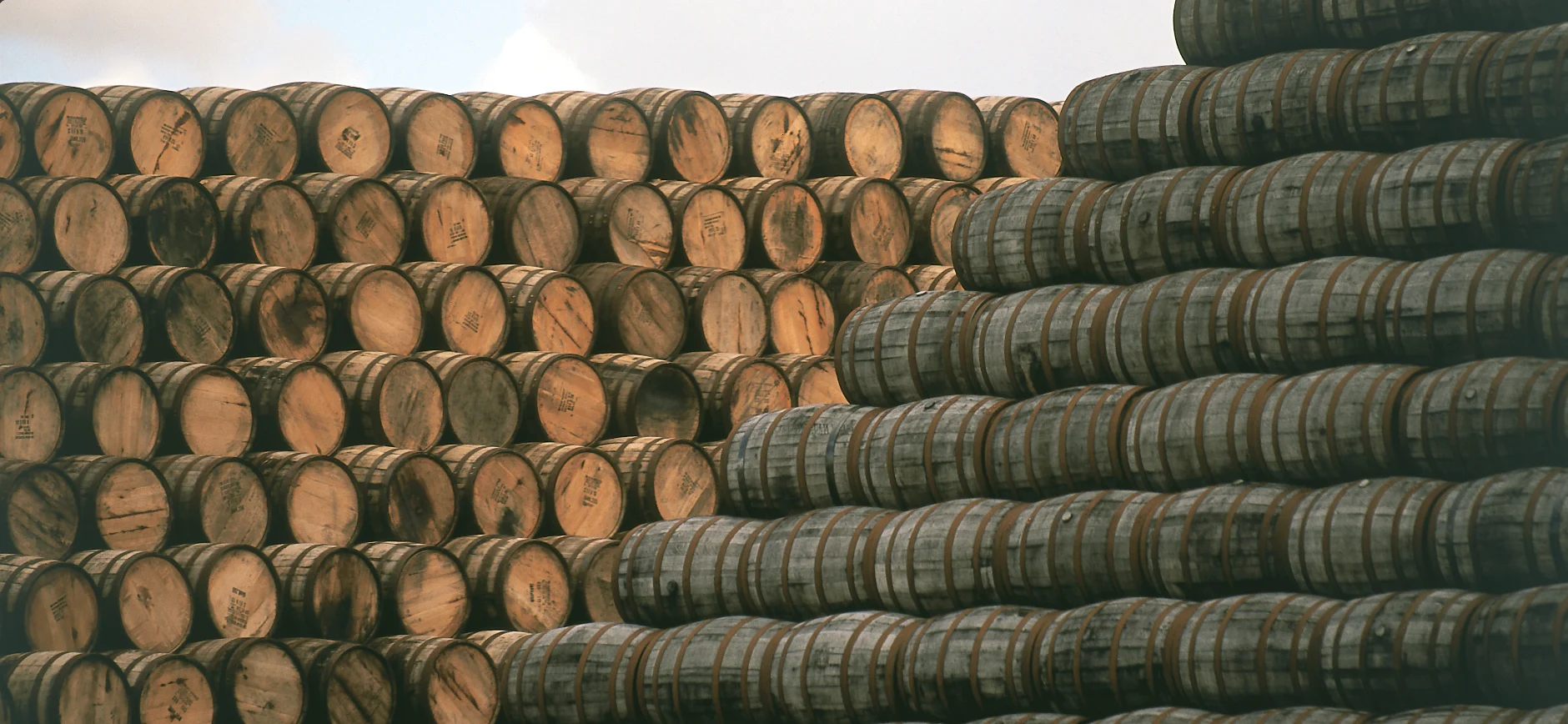 Close-up of whisky cask ends stacked in a warehouse at a Speyside distillery.