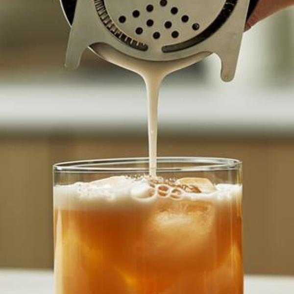 Whisky Sour Cocktail being poured into a glass