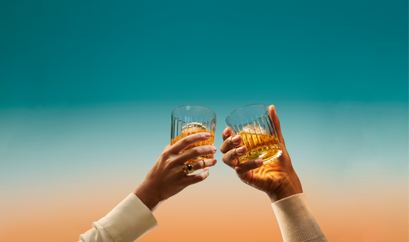 De Singleton 12-Year-Old Luscious Nectar fles met twee whiskyglazen tegen een schilderachtige achtergrond