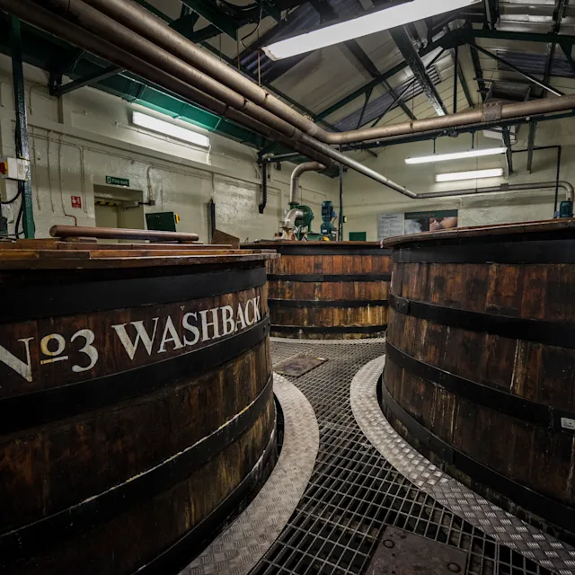 Drei hölzerne Whisky-Waschbecken werden in einem Produktionslager gezeigt