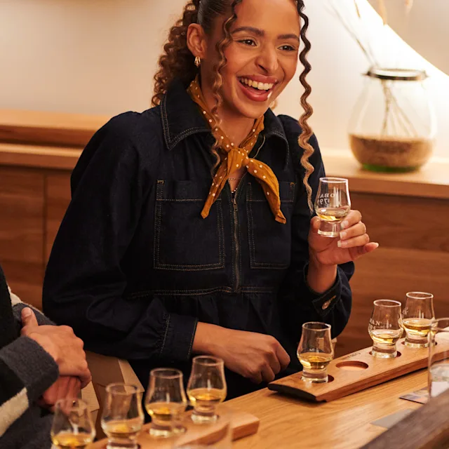 Two friends sit at a table, enjoying a whisky tasting experience at Oban distillery
