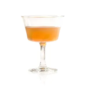 A light yellow cocktail in a coupe glass