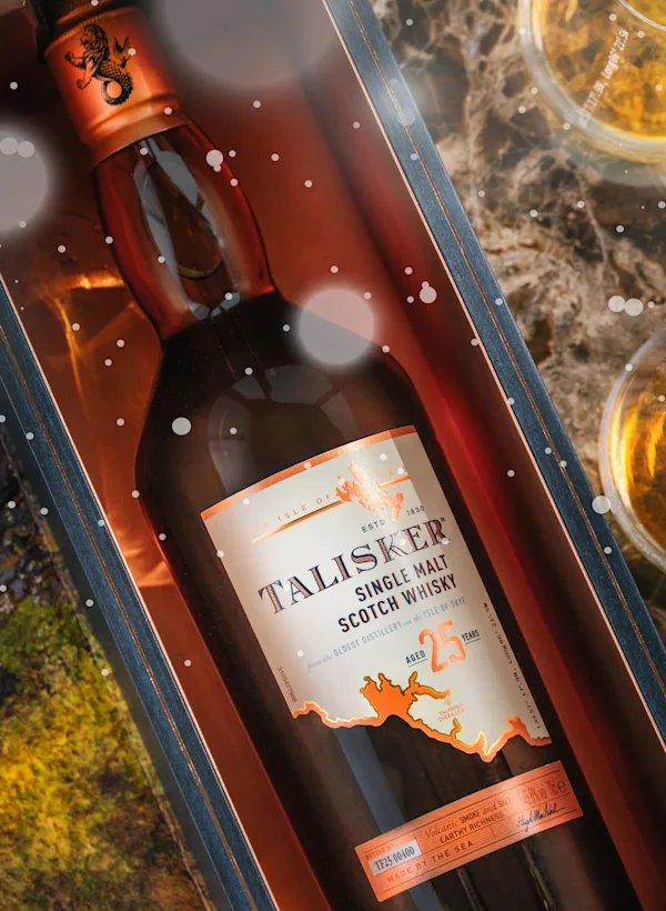 Bottle of Talisker inside a gift box and two small glasses of whisky