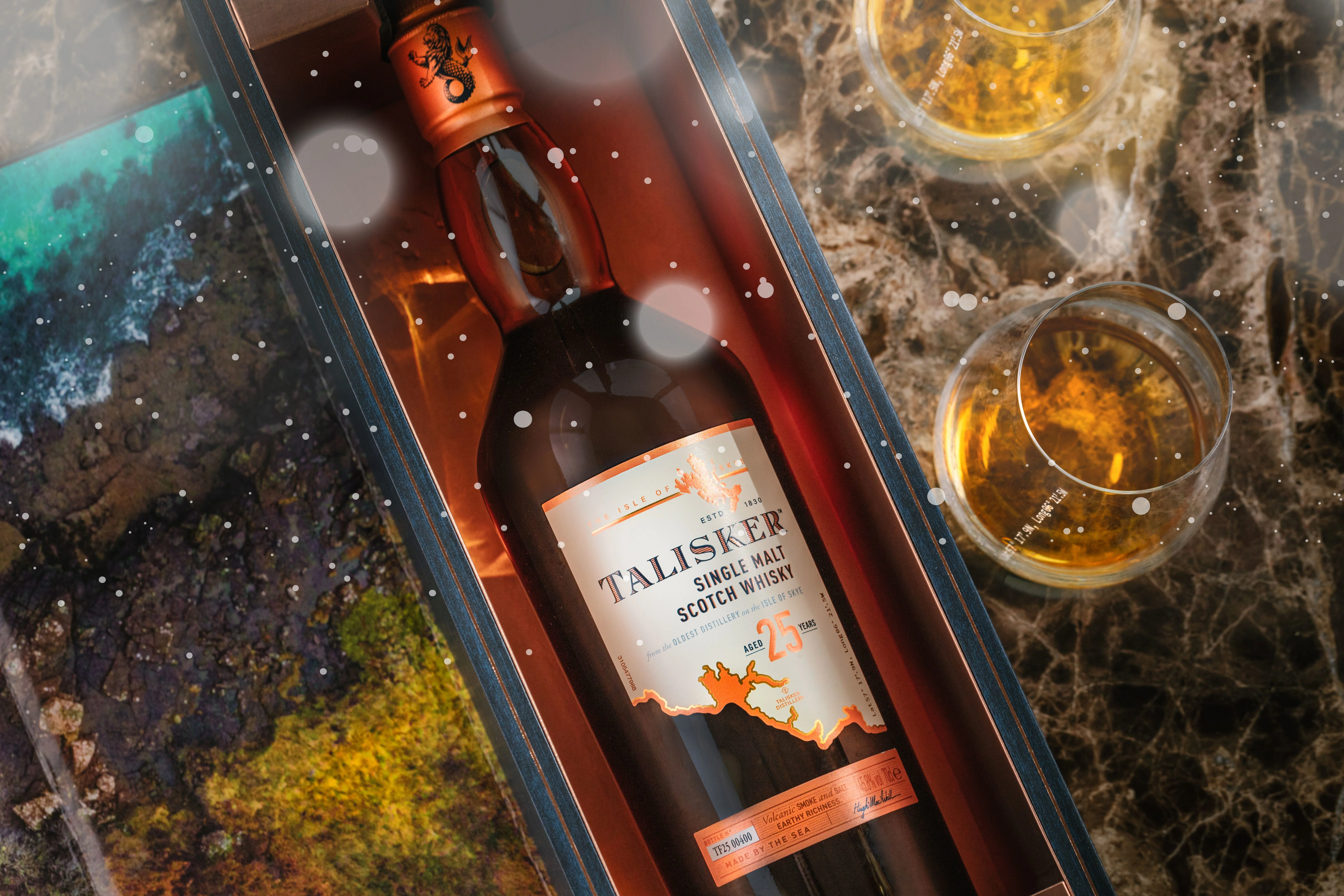 Bottle of Talisker inside a gift box and two small glasses of whisky 