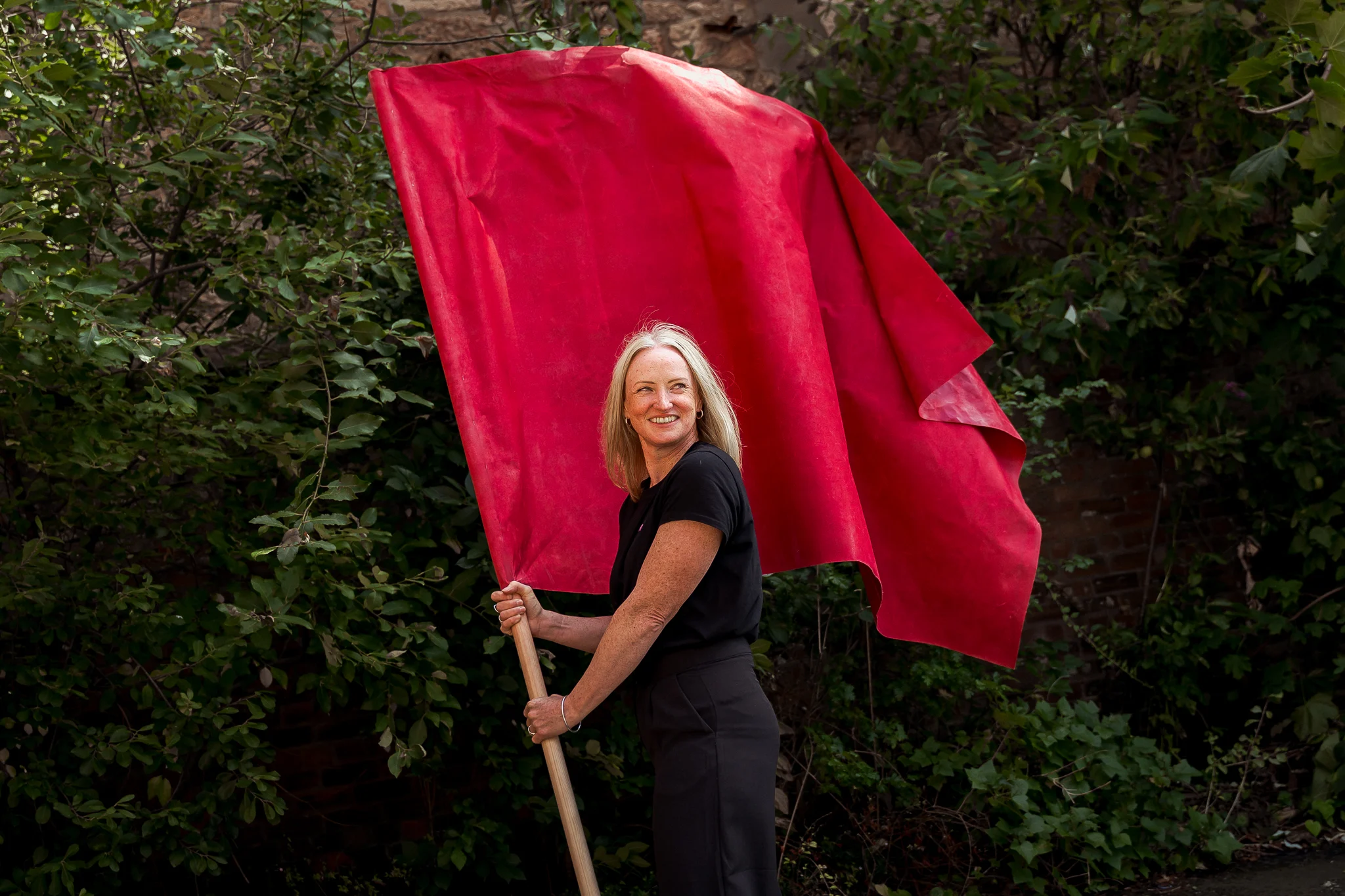 Lisa Lawson outdoors holding a red flag.