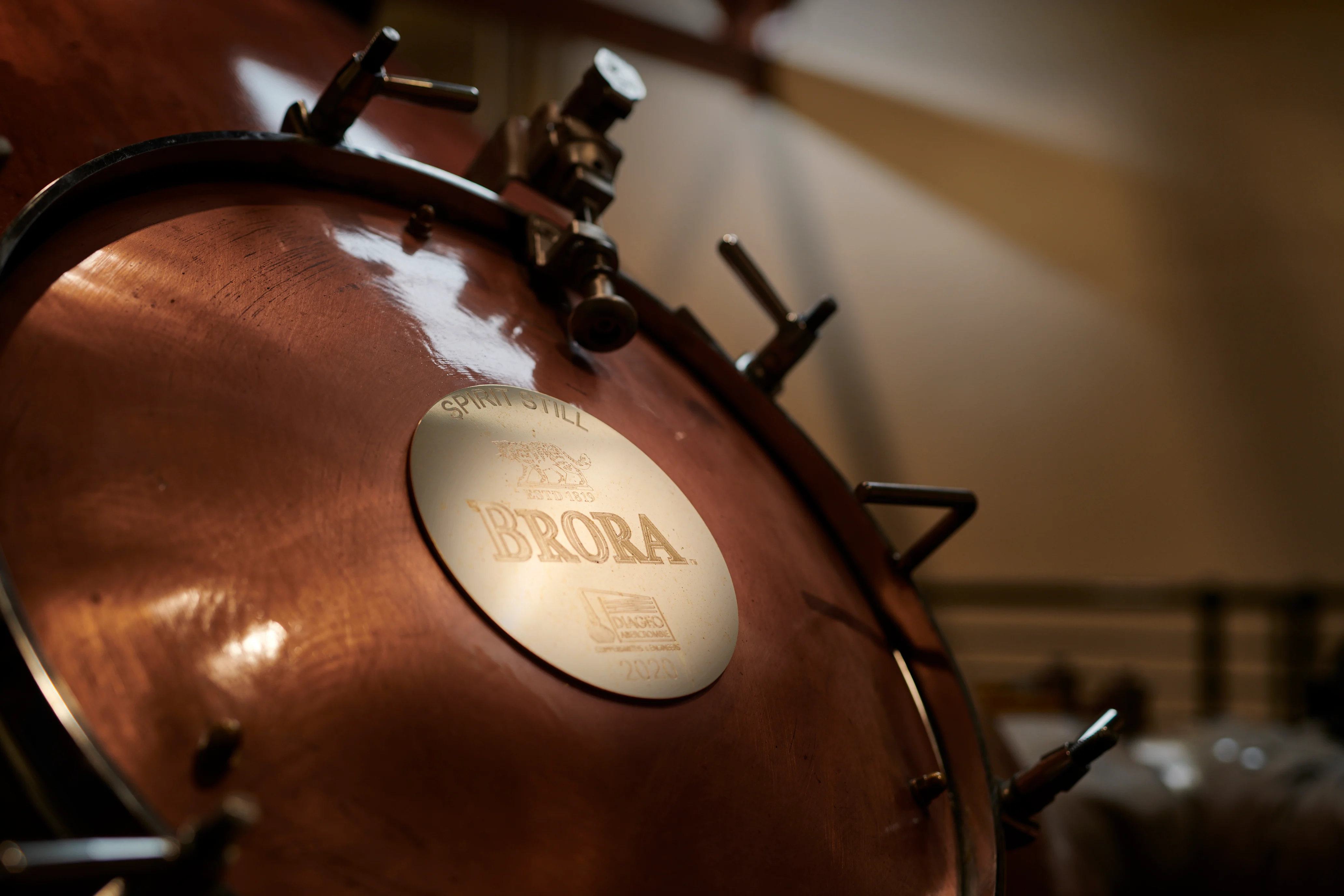 Nahaufnahme einer Whisky-Destille aus Metall mit einer Plakette mit der Aufschrift Brora und dem Logo der Brennerei.