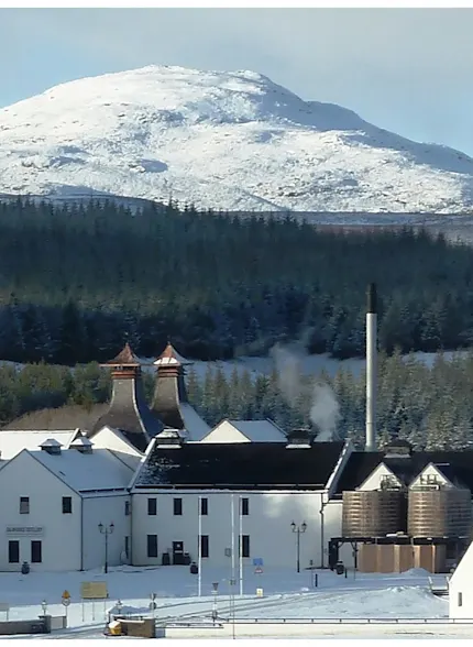 Dalwhinnie distilleerderij ligt voor een grote besneeuwde berg