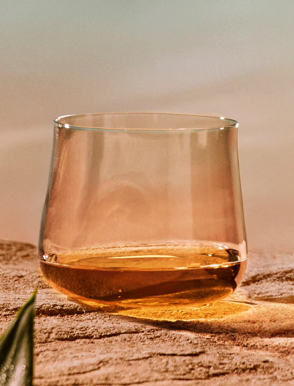 Whiskyglas gevuld met Singleton Glen Ord 17 whisky op een zanderig oppervlak