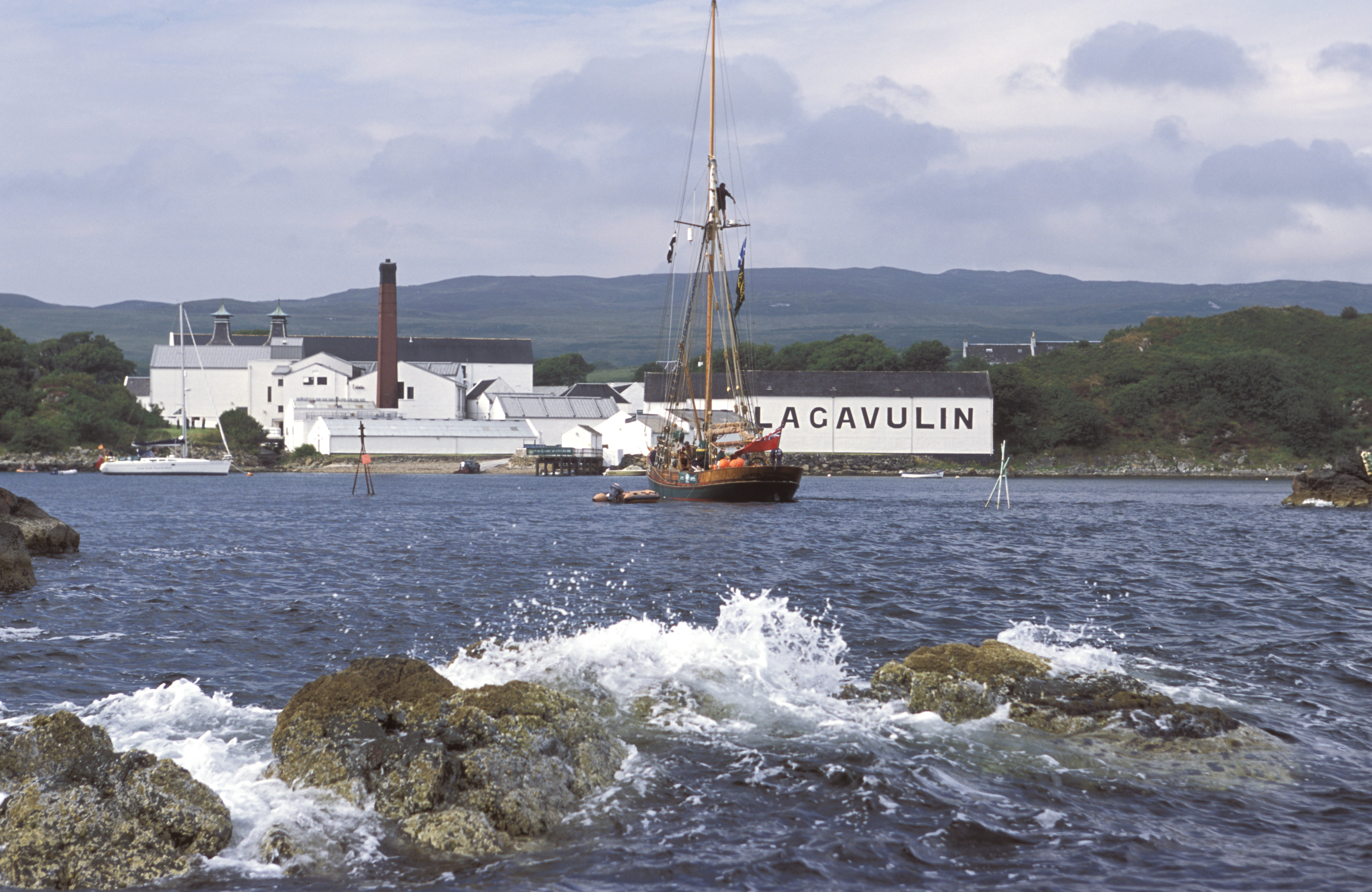 Ein Schiff segelt an der Lagavulin-Brennerei in der Bucht vorbei