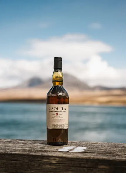 Caol Ila Feis Ile distillery release 8 year old sat in front of a body of water in Islay.