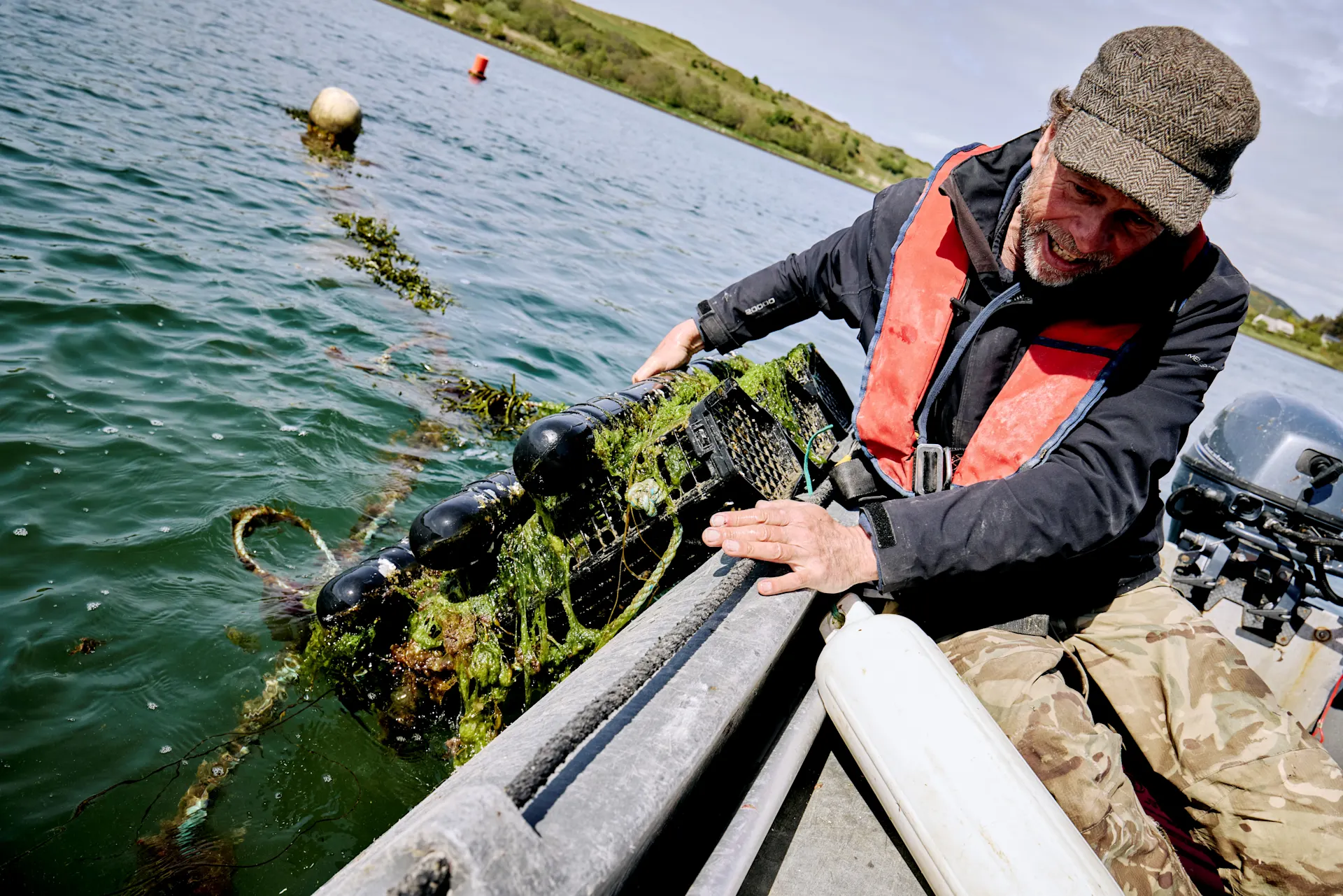 Fisherman pulling lobster crate from lake