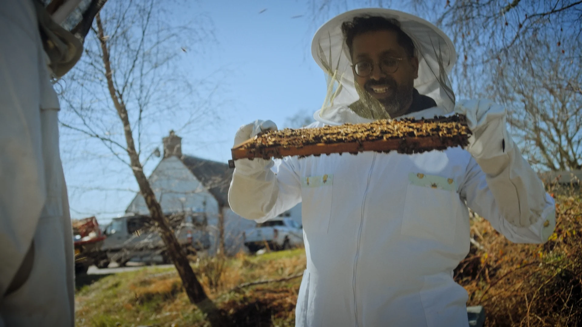 Mr Lyan visits a beekeeper and handles a hive  