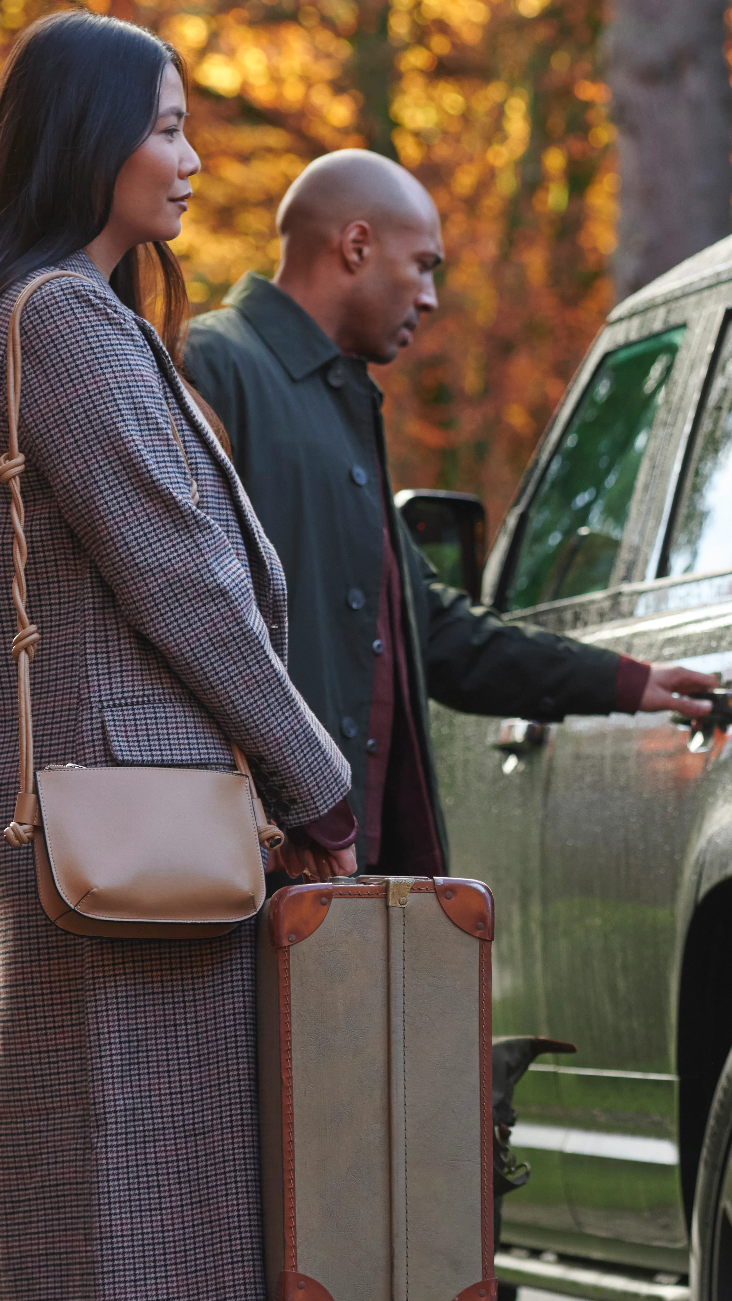 Group of travelers loading suitcases into a car before heading on a whisky trip.
