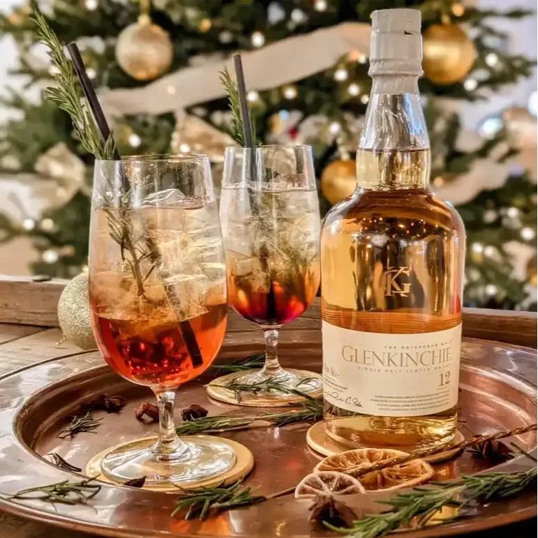 Bottle of Glenkinchie 12 with two festive cocktails in front of christmas tree