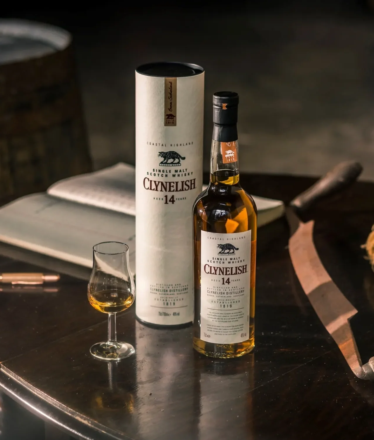 遠處有一棟斜屋頂的白色小建築。前景是一排黃綠相間的灌木叢，襯托出一片空曠的田野。房子周圍是田野，遠處是一座山。