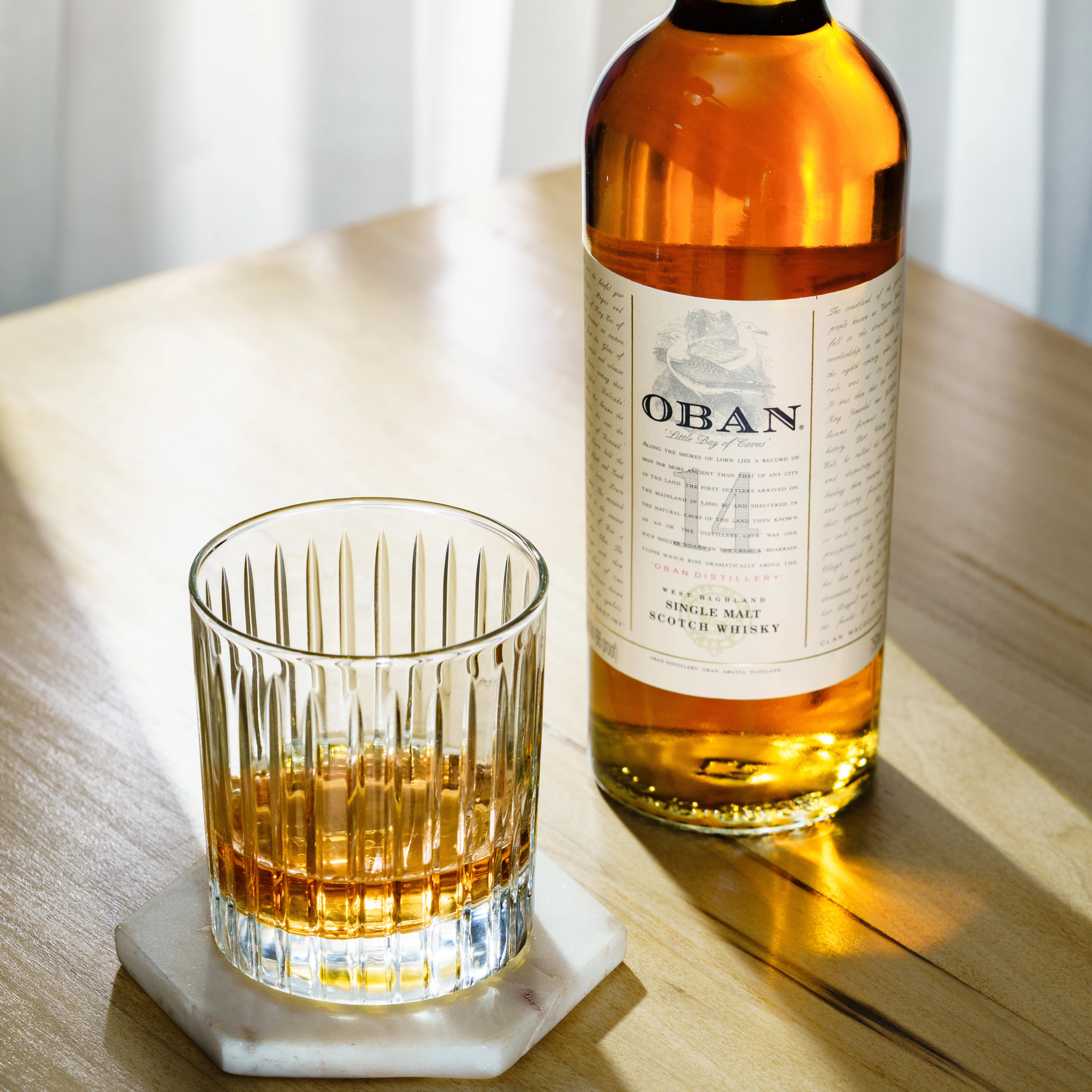 Image of a glass of Oban neat and a bottle of Oban 14