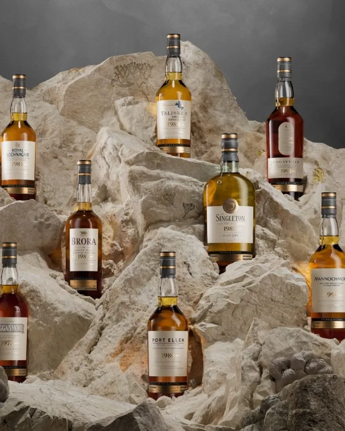 Multiple bottles of whisky displayed on a rocky background