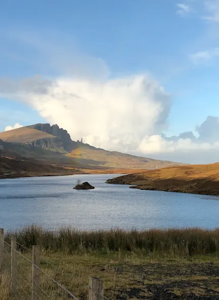 Een Schots loch wordt van een afstand afgebeeld met het omringende berglandschap.