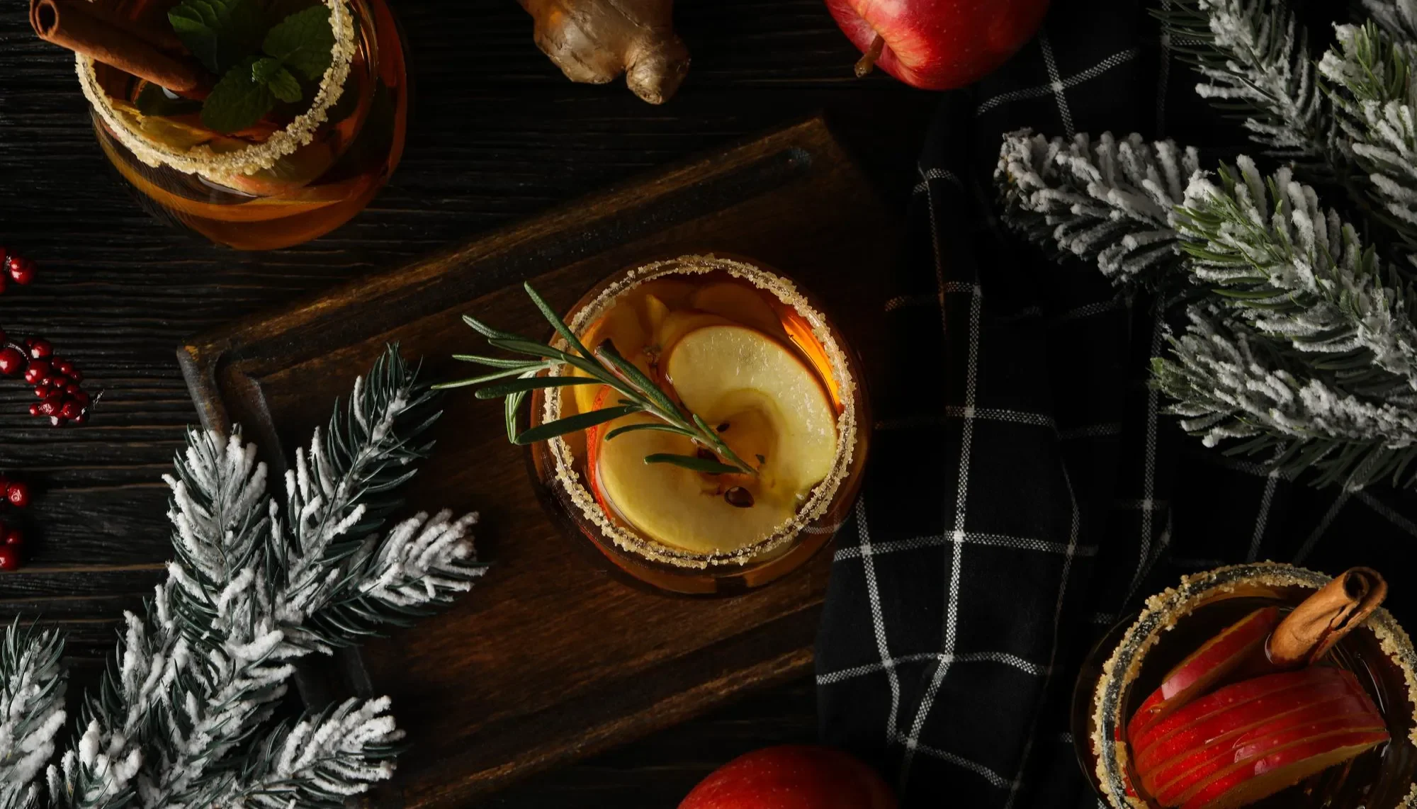 Winter cocktail on a tartan blanket surrounded by fir tree branhes