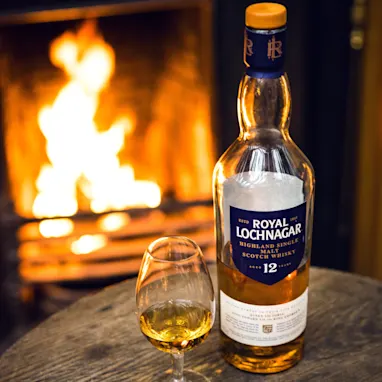 Royal Lochbgar bottle in front of a active firs place