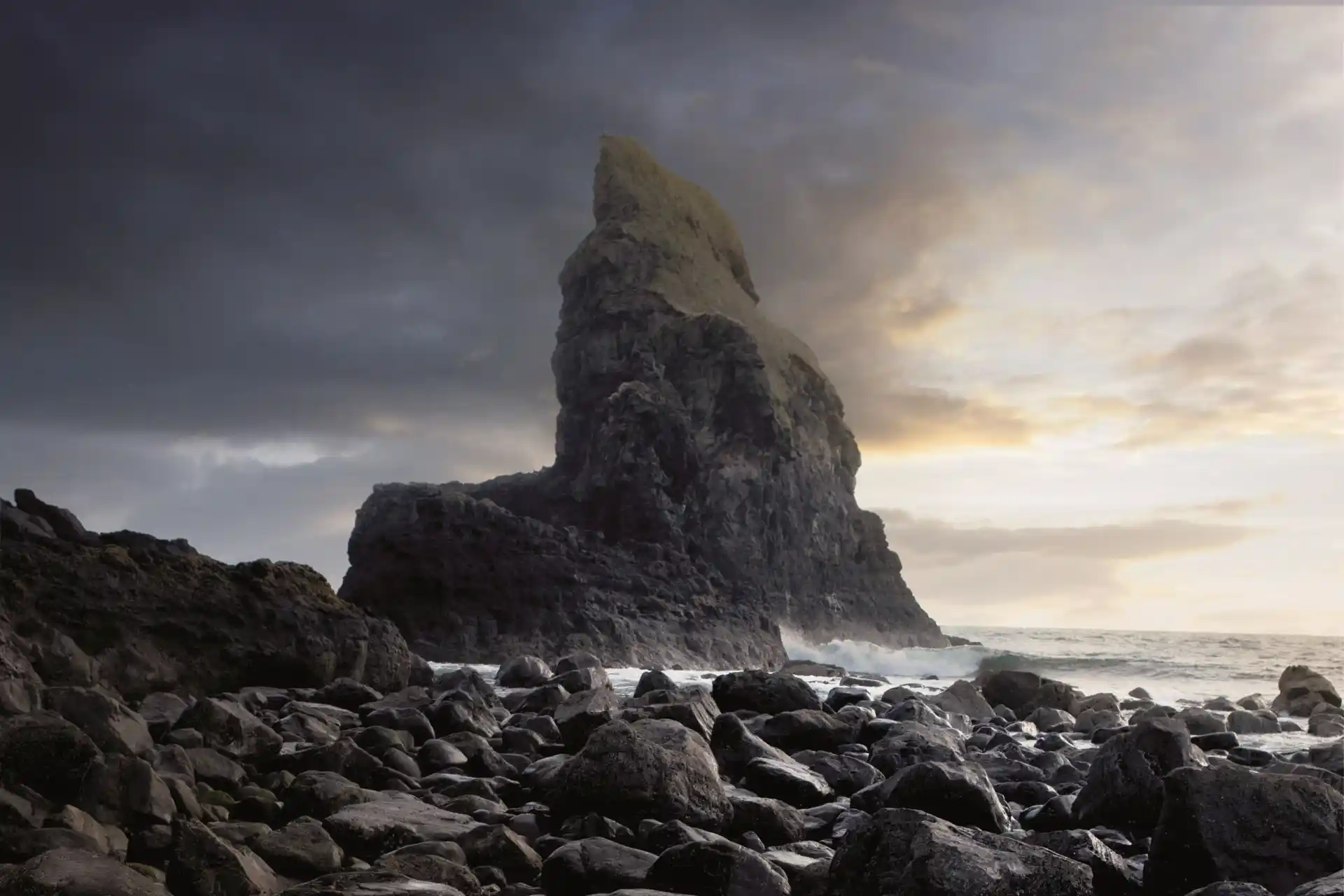 The rugged landscape of the Isle of Skye, featuring a rocky shoreline and a large mountain.