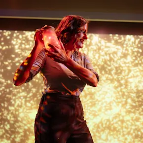 A man in a neon lit room intrigued whilst observing bottles holding ingredients whilst experience the tour.