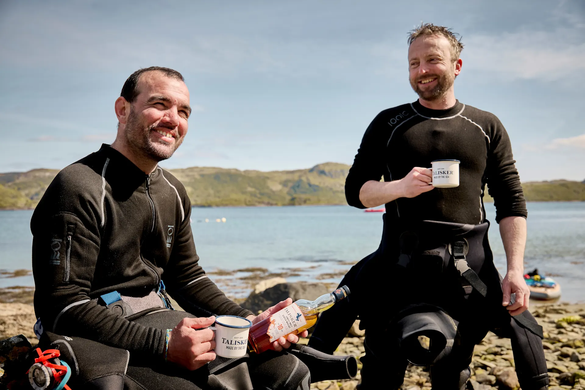 Two local Scottish fishermen with a bottle of Talisker Whiskey and Talisker mugs