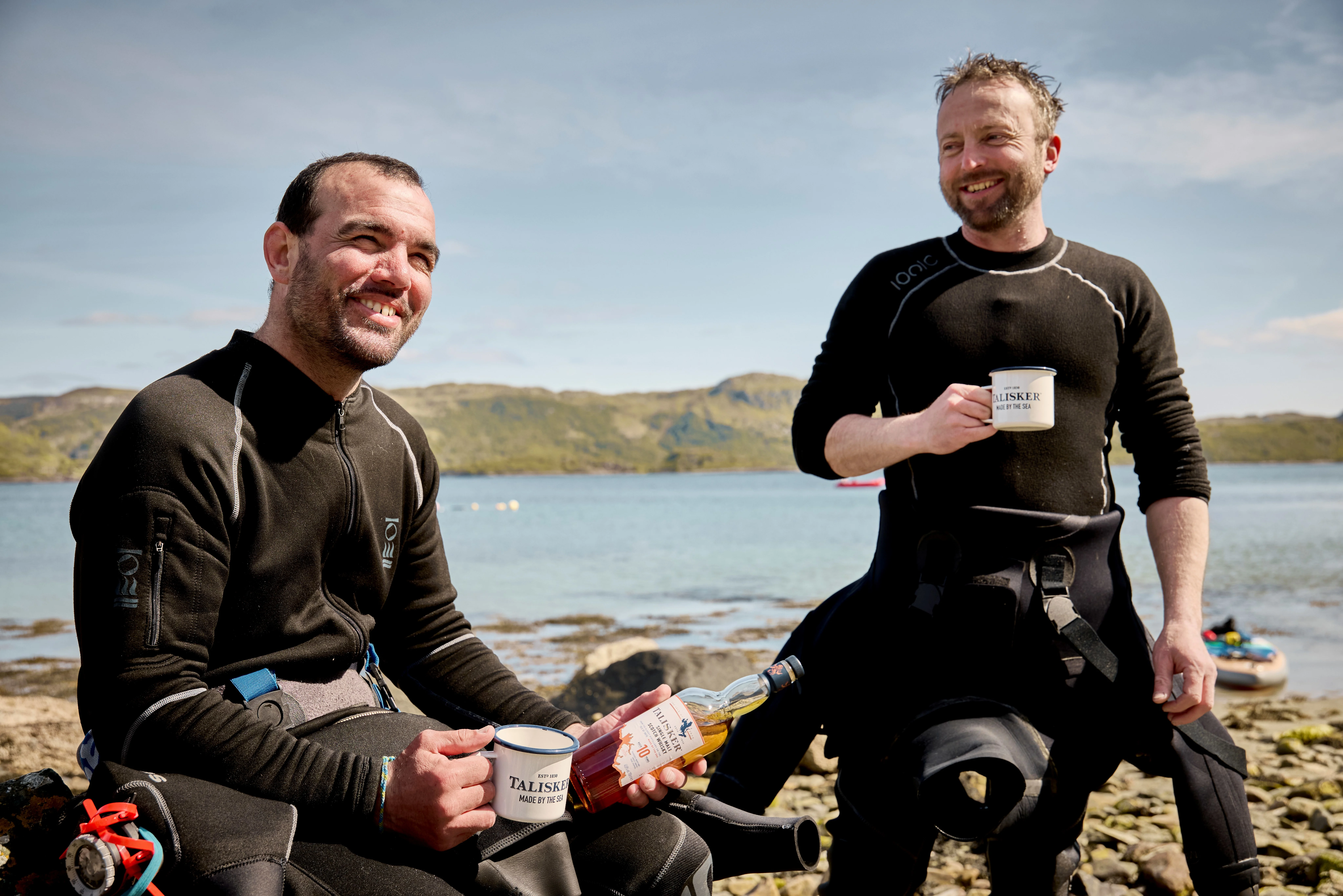 Two local Scottish fishermen with a bottle of Talisker Whiskey and Talisker mugs