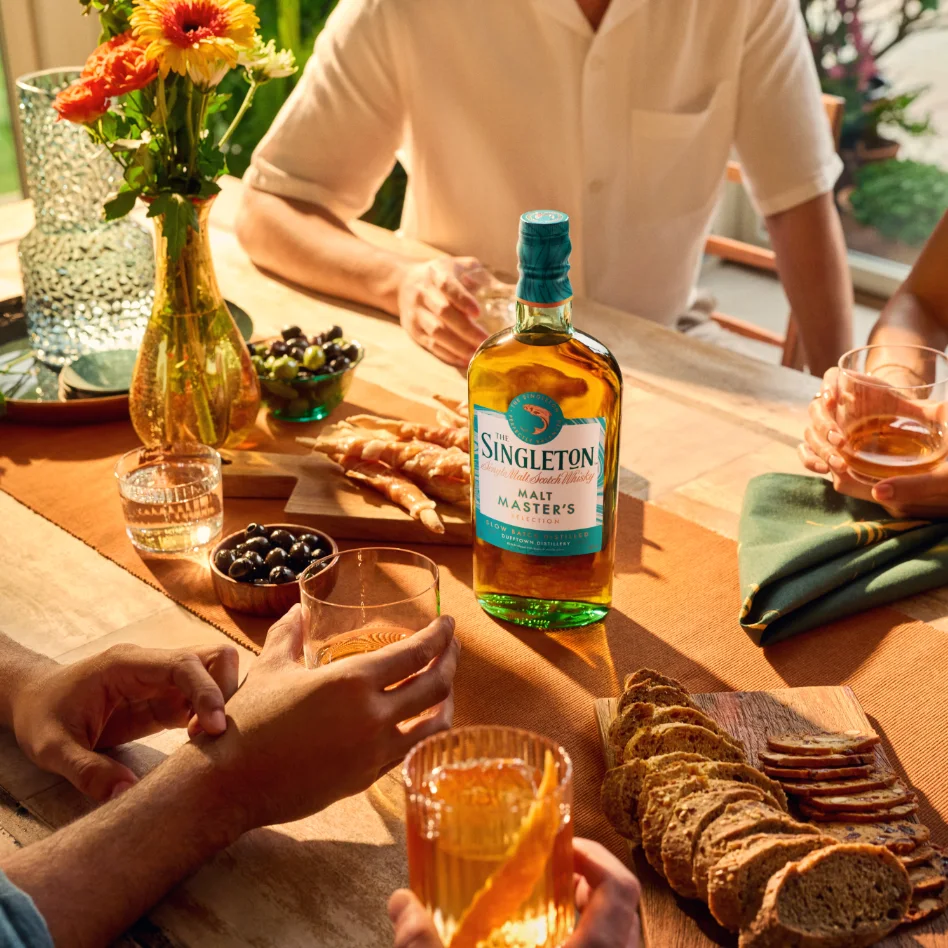 Friends around a dining table drinking The Singleton of Dufftown Malt Master's Selection Single Malt Scotch Whisky