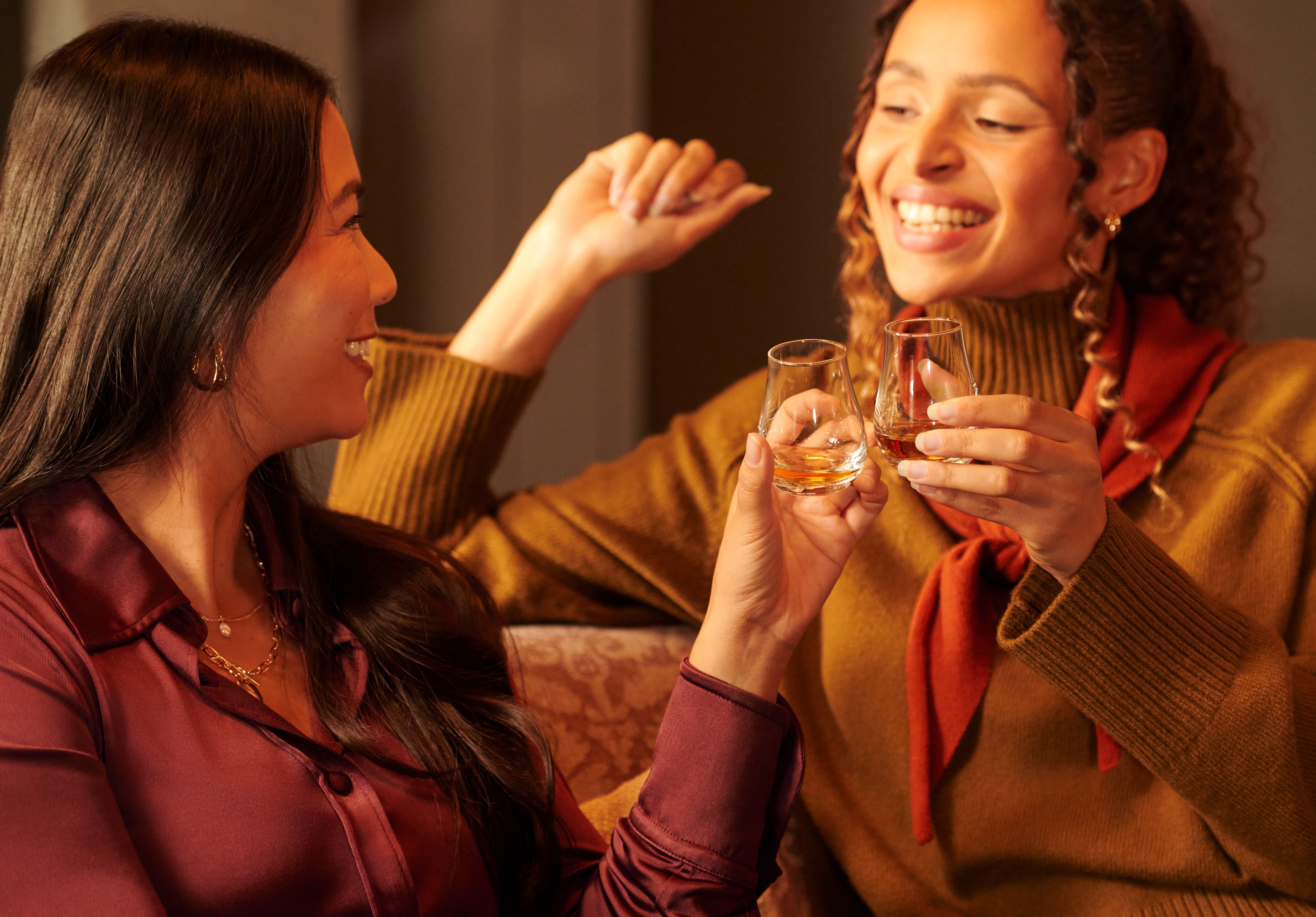 Two women drinking from whisky tasting glasses