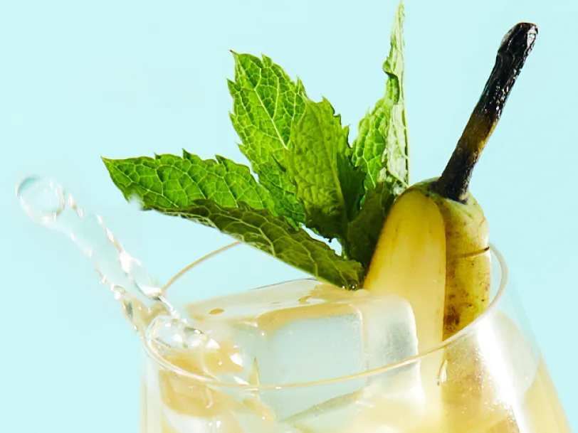 A highball whisky cocktail with a pear and mint garnish.
