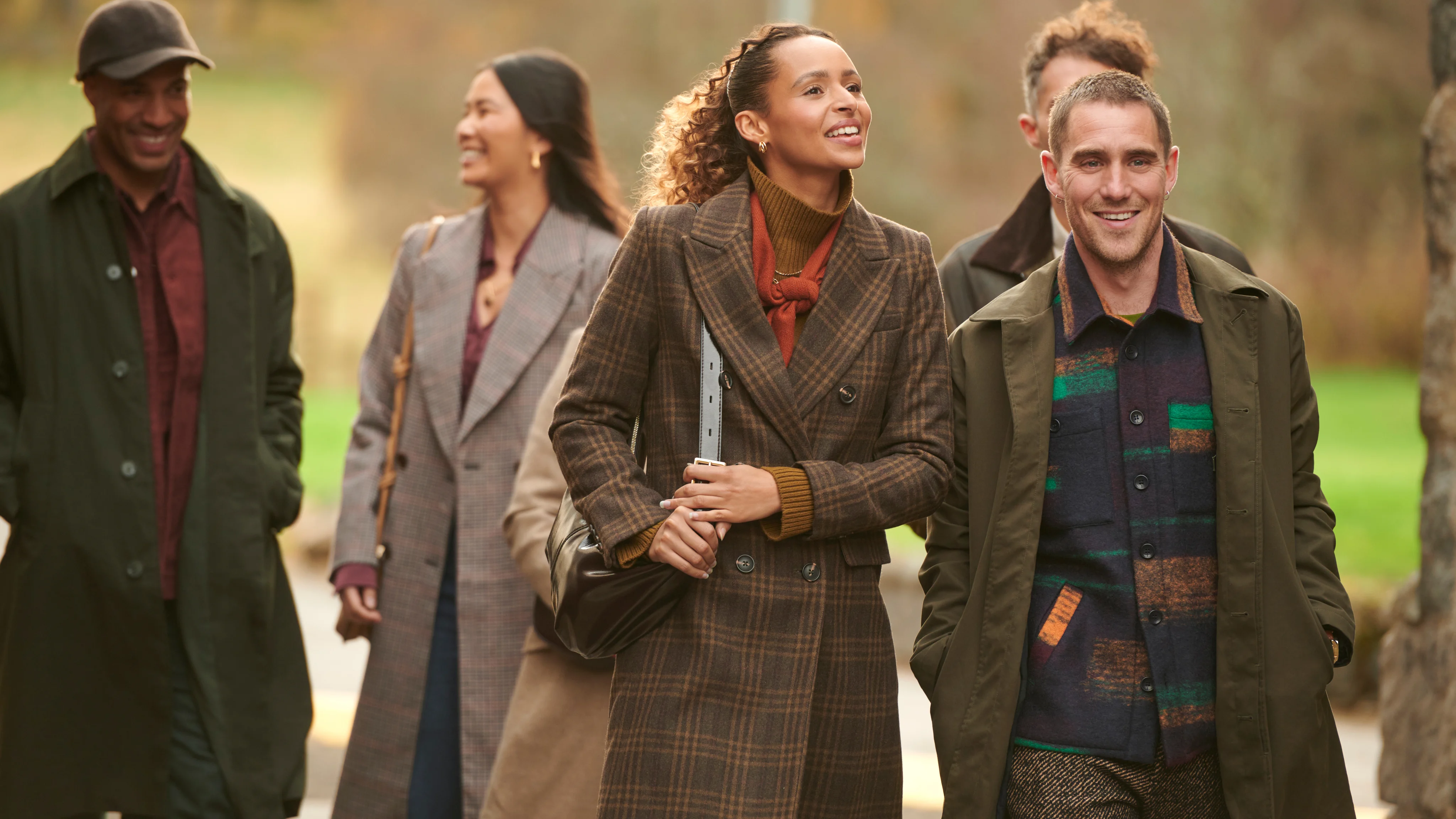 Group of friends walking through countryside near Edinburgh on a distillery tour.