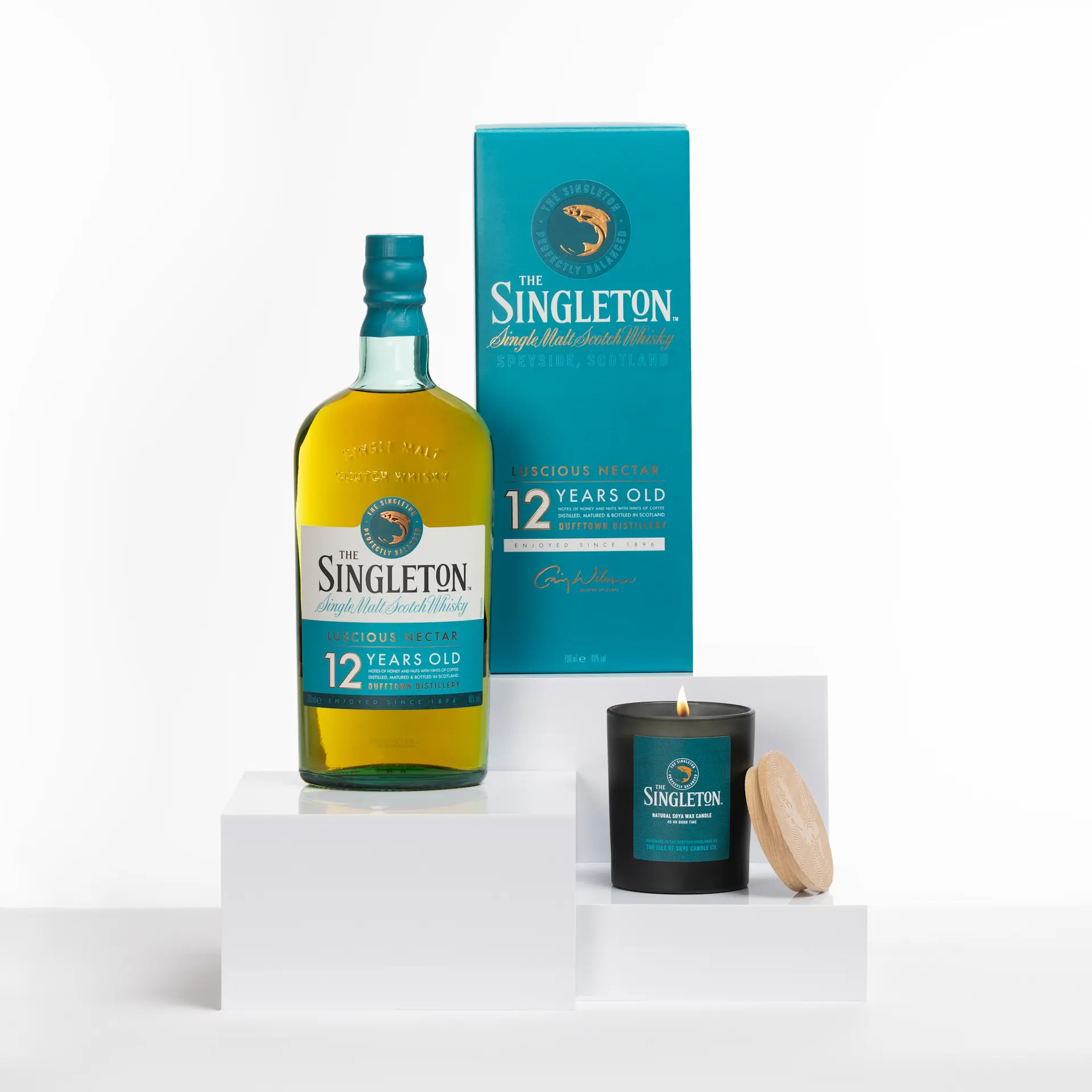 Der Singleton 12-Year-Old Single Malt Scotch Whisky steht neben seiner charakteristischen Kerze mit Holzdeckel in einem minimalistischen weißen Display.
