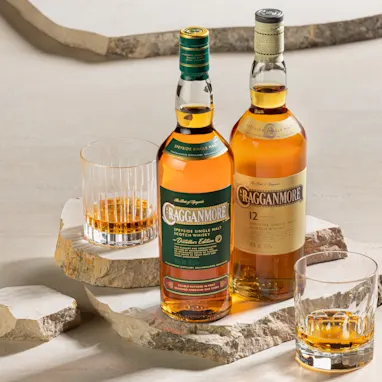 Een man brengt met een poederkwast goudglanzende stof aan op een gouden ster op een houten vat. Op het vat staat in witte letters 'D & J McCallum Ltd, 1985 Cragganmore 1272'.