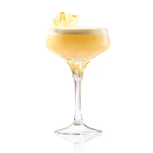 A light yellow cocktail in a coupe glass, with a white foamy top and a dried pineapple slice garnish
