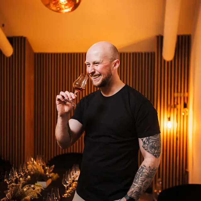 Ein Mann probiert Whiskey aus einem kleinen Glas bei Fèis Ìle