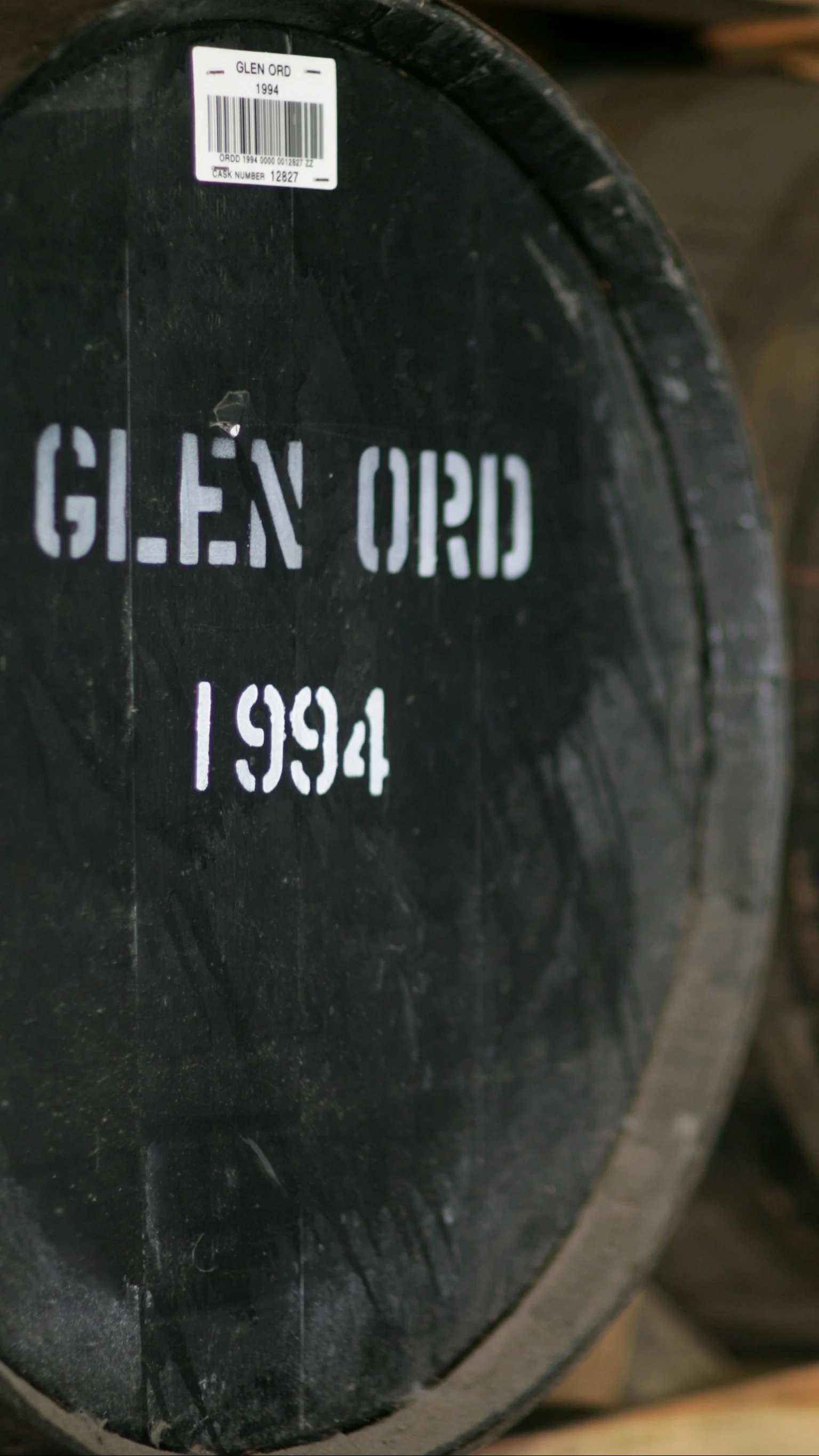 Whisky barrels marked Glen Ord 1994 inside a traditional aging warehouse.