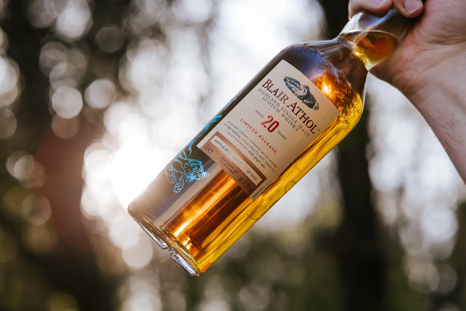 Een close-up van een hand die een fles Blair Athol 20 jaar oude Highland Single Malt Scotch Whisky Limited Release vasthoudt. 