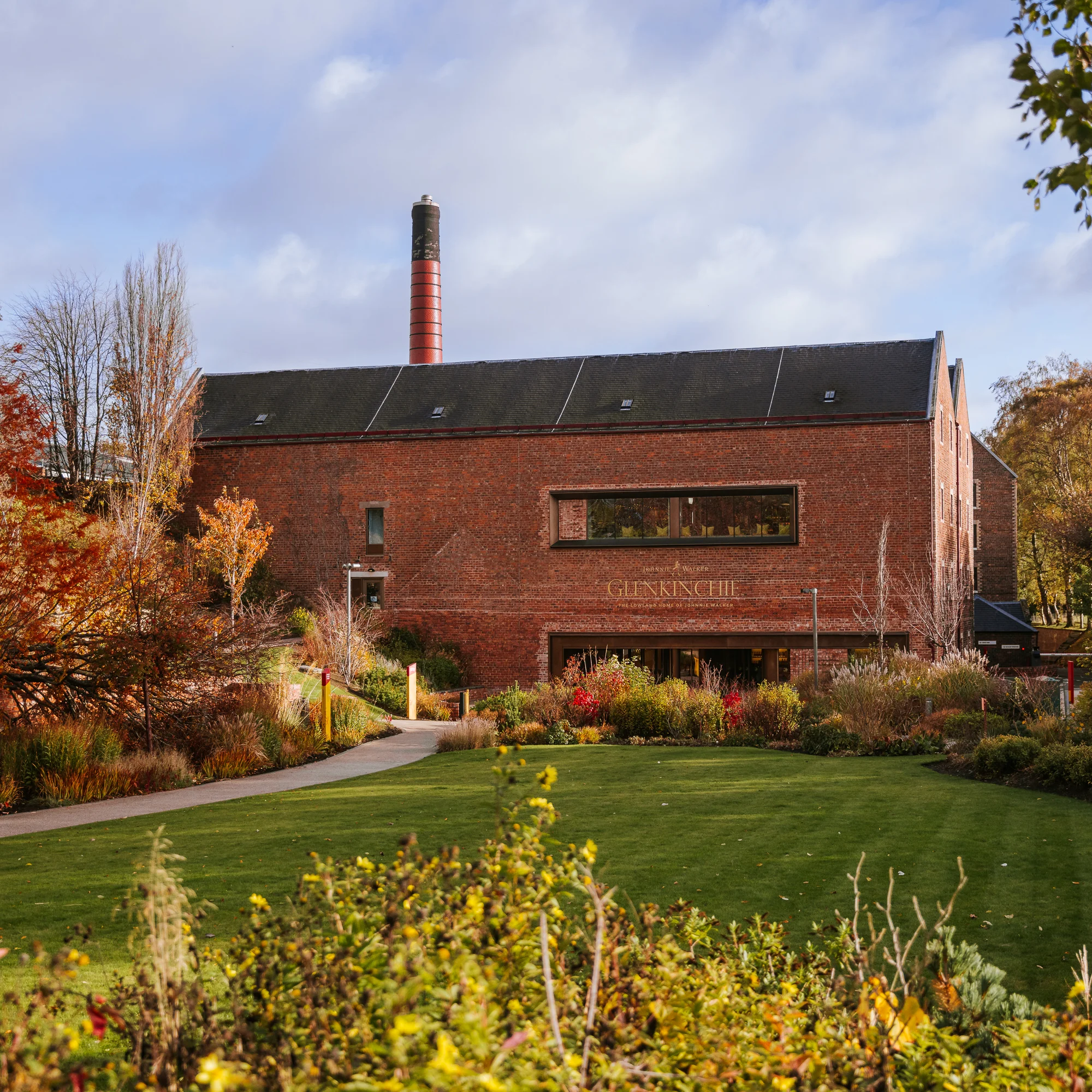 Exterior of Glenkinchie Distillery building surrounded by greenery near Edinburgh.