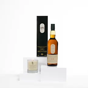 Lagavulin 16-Year-Old Single Malt Scotch Whisky gepaart mit einer luxuriösen Duftkerze, elegant präsentiert auf einem weißen Podest.