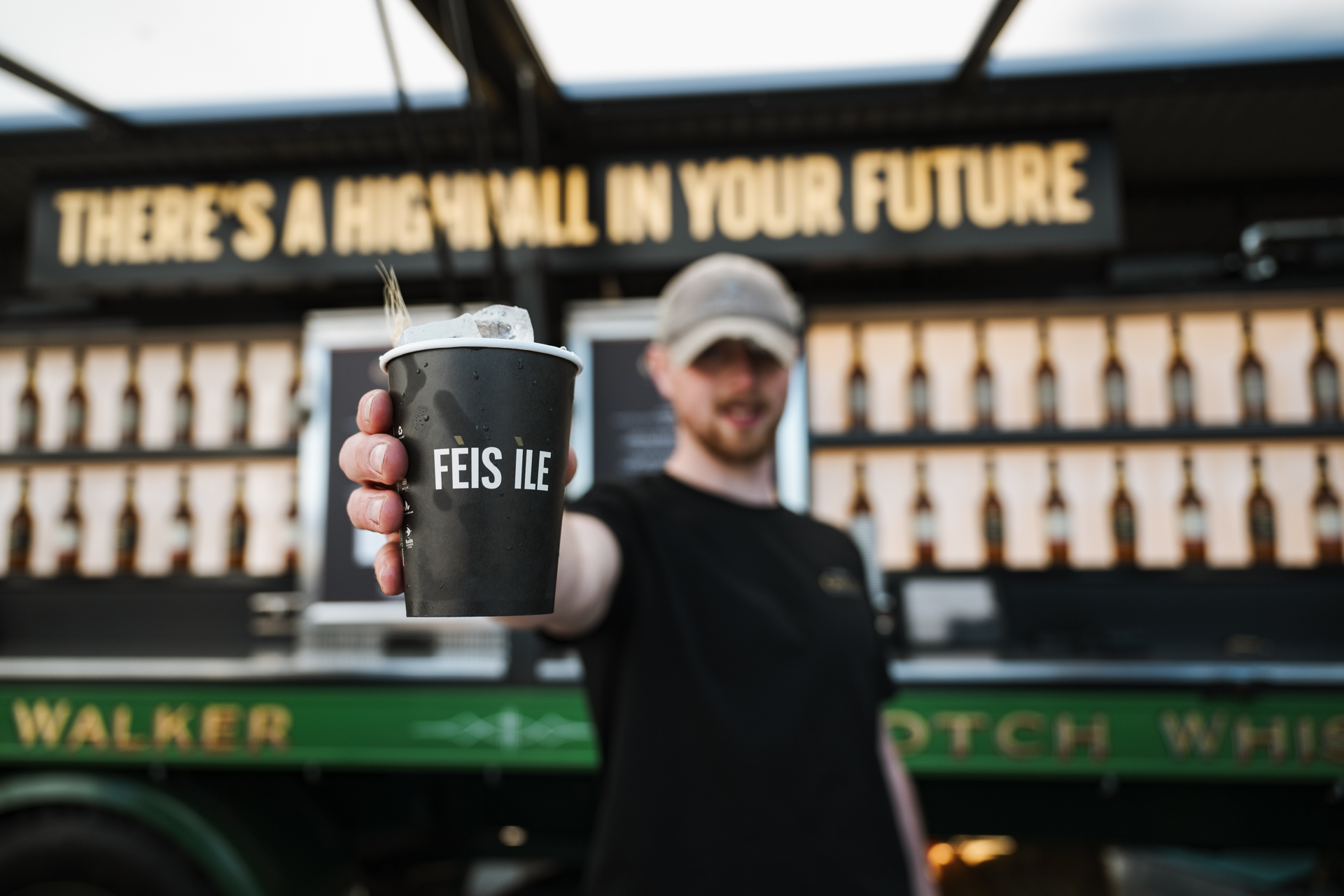Ein Barkeeper zeigt einen Highball-Cocktail in einem Fèis ìle-Becher.