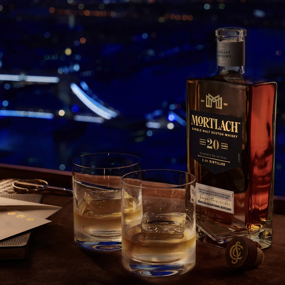 一瓶20年陸克威士忌、一杯威士忌和幾片在火上烤的牛肉。