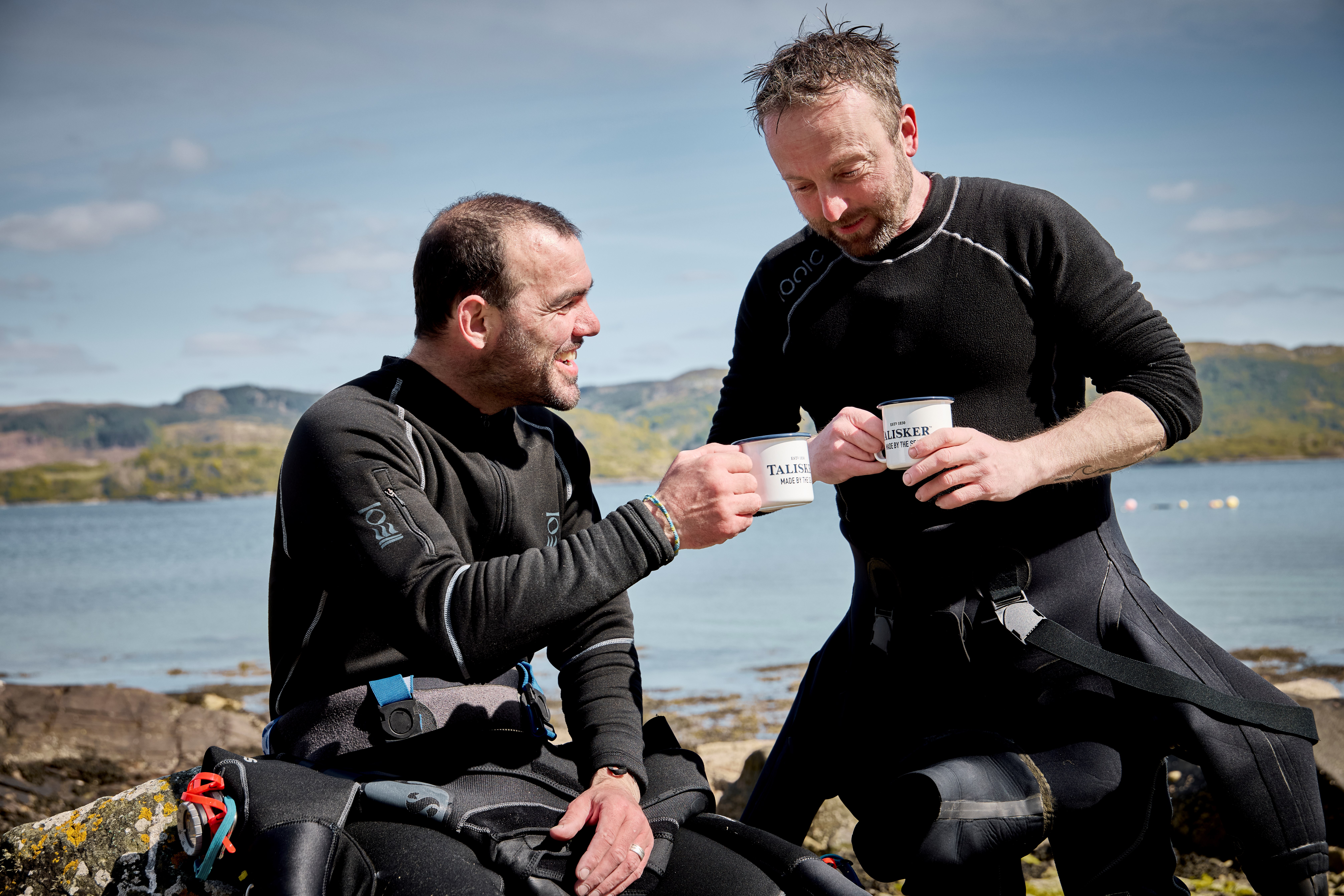 Two fisherman drinking from Talisker mugs