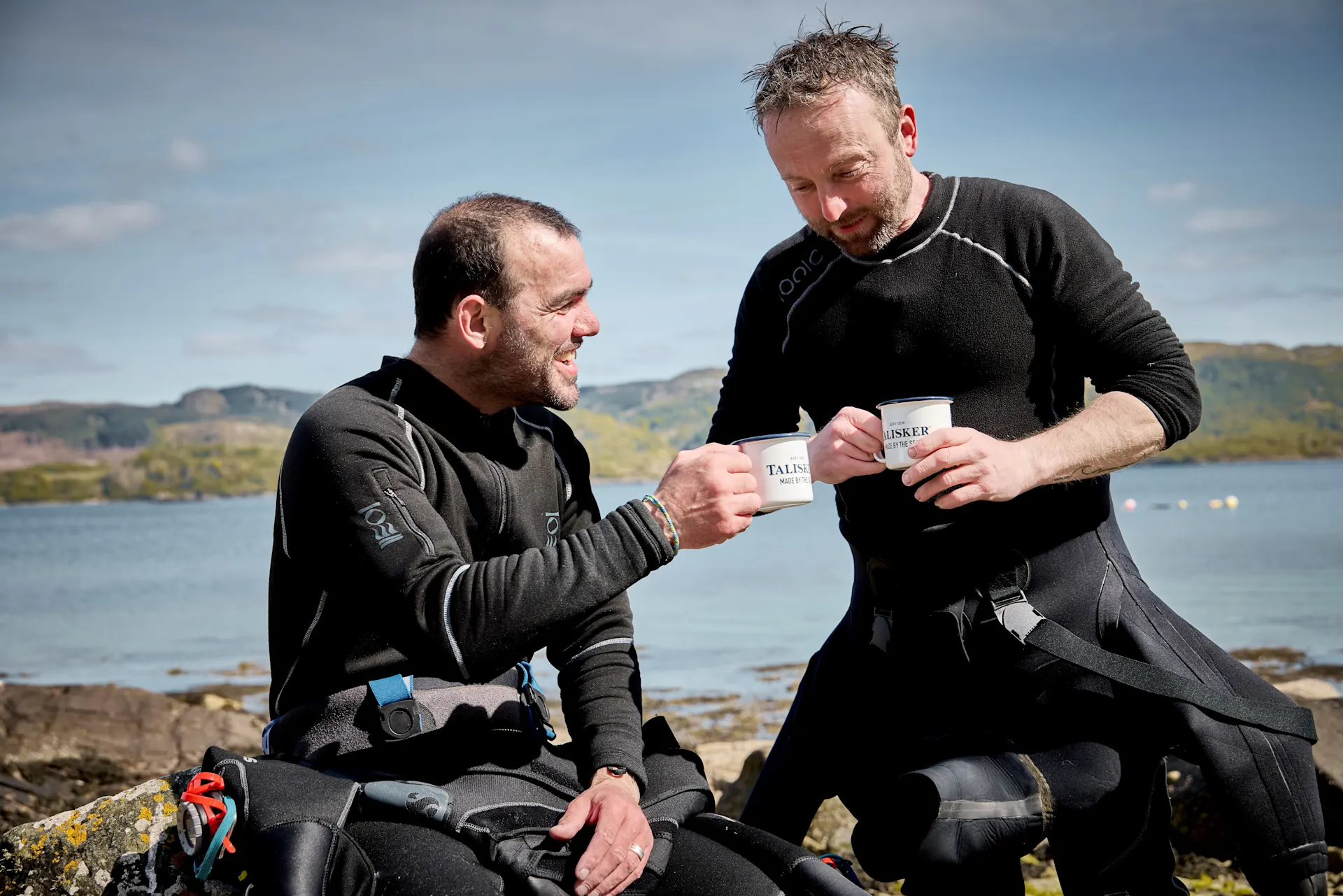 Two fisherman drinking from Talisker mugs