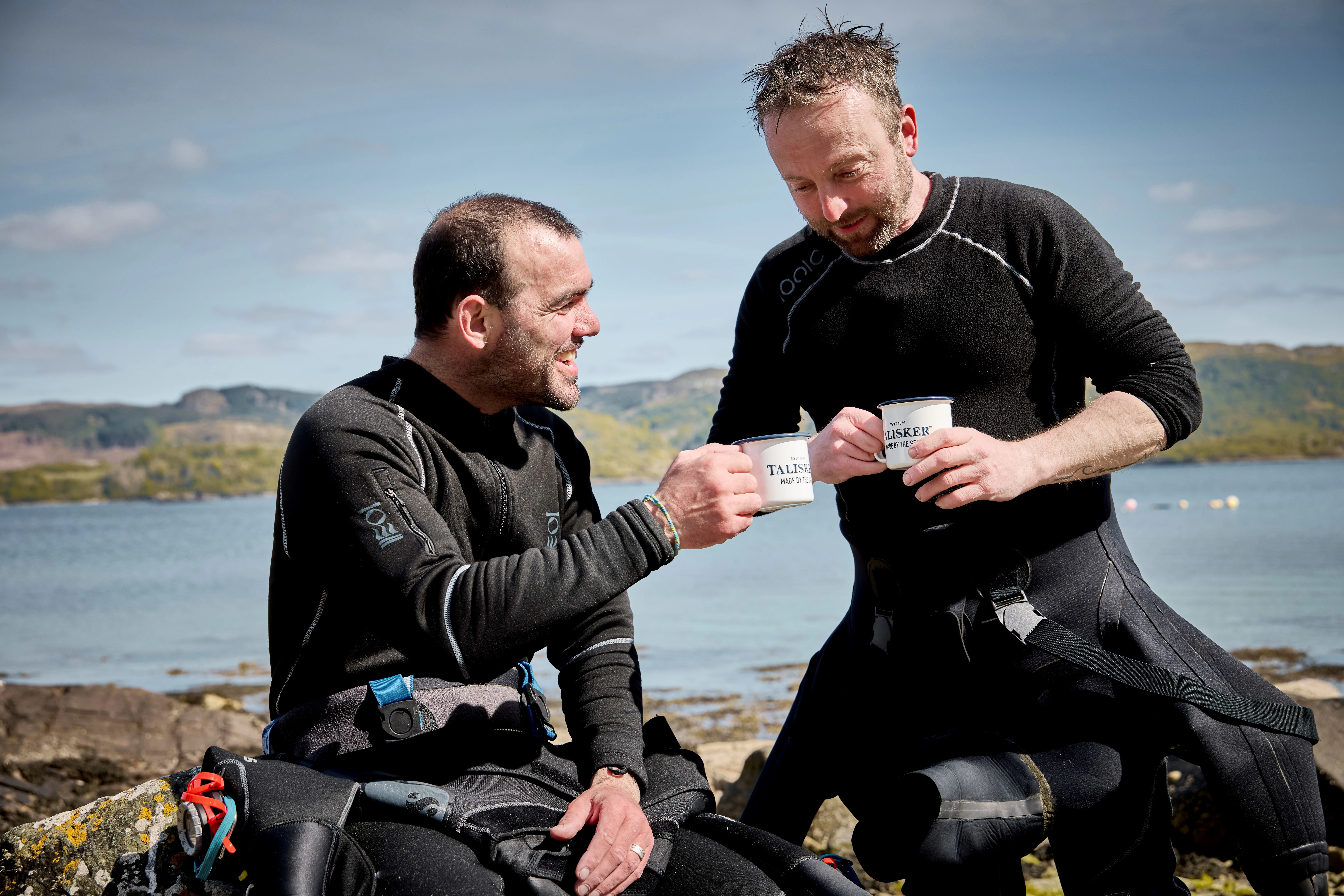 Two fisherman drinking from Talisker mugs
